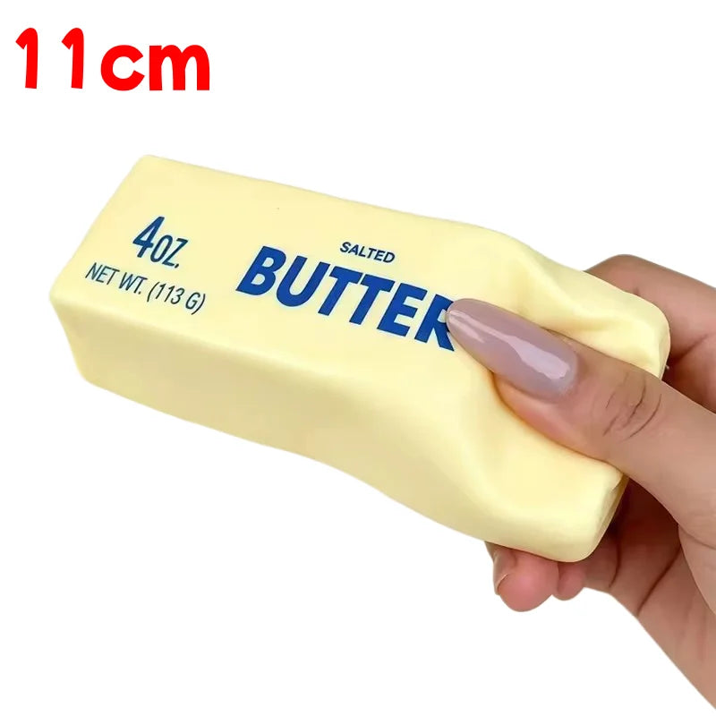 A yellow salted butter stick squishy toy being held by a hand.