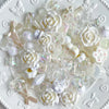 A pile of clear and white acrylic bow and flower beads for DIY jewelry making