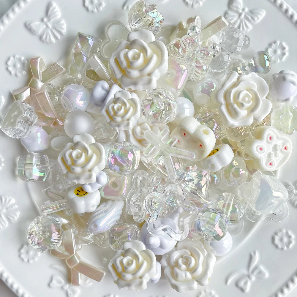 A pile of clear and white acrylic bow and flower beads for DIY jewelry making