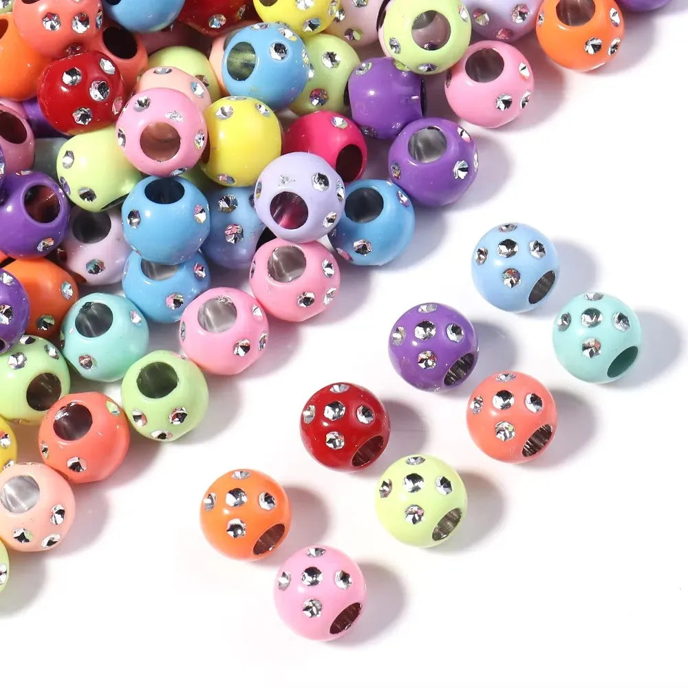 A collection of colorful rhinestone acrylic spacer beads in various shades and sizes.