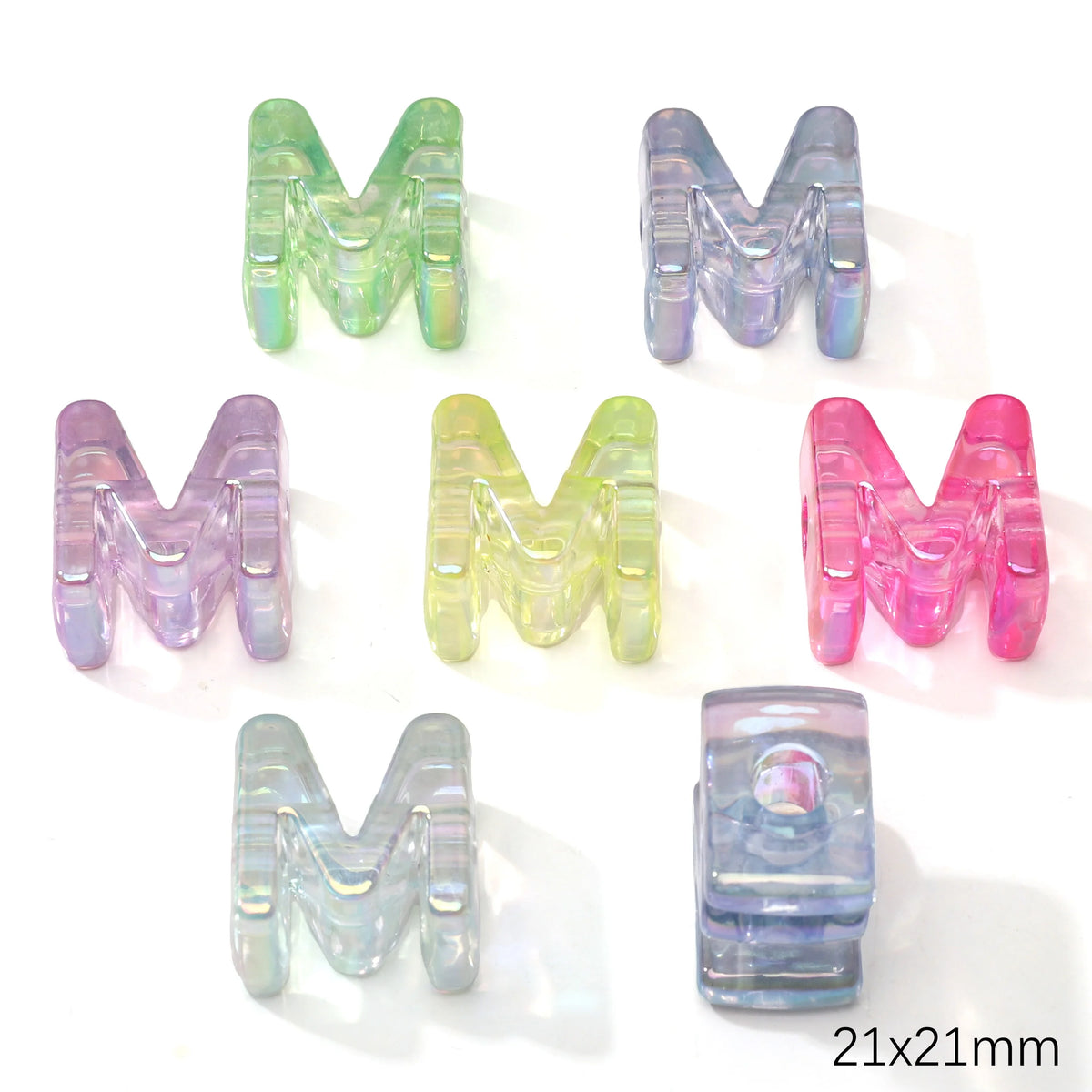A collection of colorful acrylic letter M beads in various shades and transparencies.