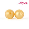 Two round, yellowish silicone beads are shown against a white background.