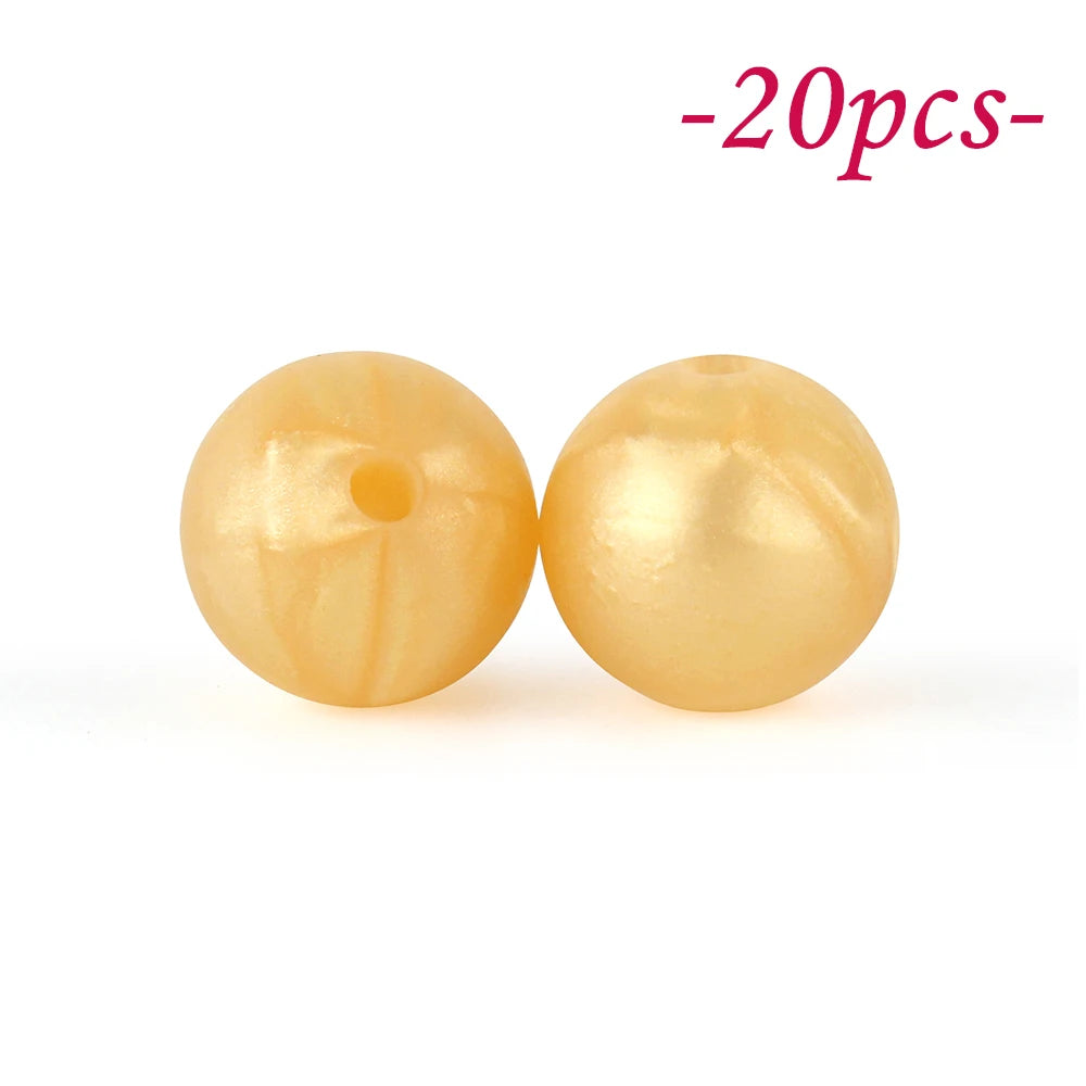 Two round, yellowish silicone beads are shown against a white background.