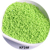 A pile of bright lime green seed beads in a white bowl.