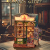 A detailed miniature building of a shop called Magic Shop featuring wooden elements and glass display windows.