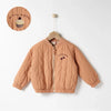 A light brown padded jacket for kids featuring a letter print on the chest, displayed on a hanger.