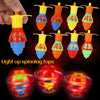 A hand holds several glow-in-the-dark spinning tops in various colors and shapes.
