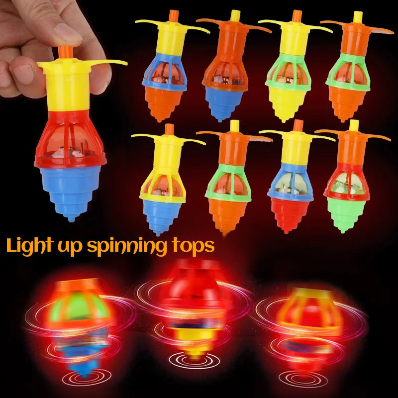 A hand holds several glow-in-the-dark spinning tops in various colors and shapes.