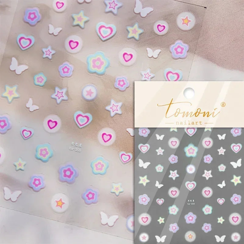Sheet of nail art stickers featuring various pastel colored flowers, hearts, and butterflies on a translucent background