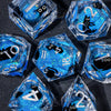 A collection of clear blue liquid core resin dice in various geometric shapes and angles