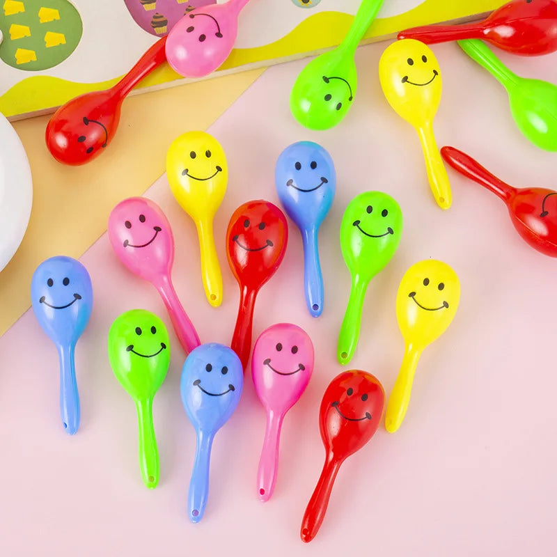 A collection of colorful mini maracas shaker toys in various bright colors like pink, yellow, green, and red.