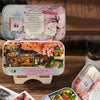 A wooden miniature dollhouse theater kit featuring a detailed scene of cherry blossoms and a traditional building.