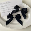 Black satin ribbon bow with a rhinestone heart embellishment