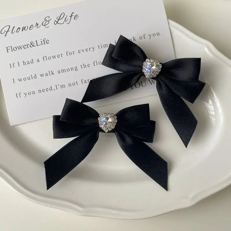 Black satin ribbon bow with a rhinestone heart embellishment