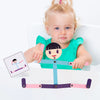 A toddler is holding a wooden stick puzzle toy set with pink and purple pieces.
