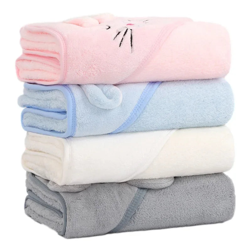 A stack of pink, light blue, white, and gray hooded animal bath towels for babies and toddlers.