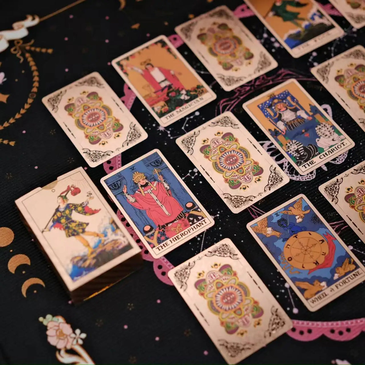 A collection of mini gold foil tarot cards laid out on a dark surface.