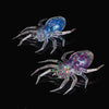 Two laser-reflective spider soft bait lures, one blue and one purple, displayed against a black background.