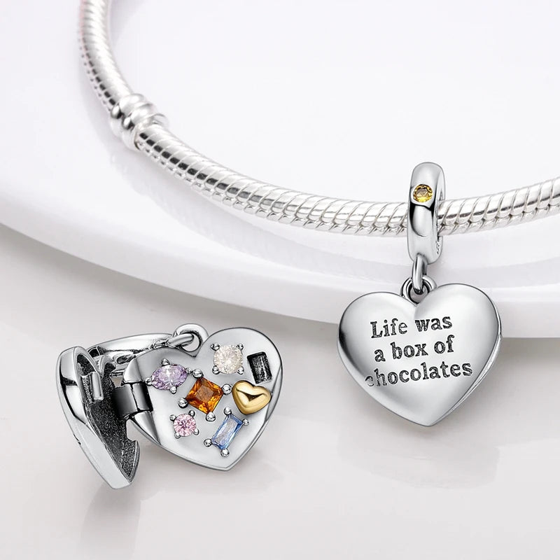A sterling silver heart pendant charm with various colored gemstones hangs from a silver chain.
