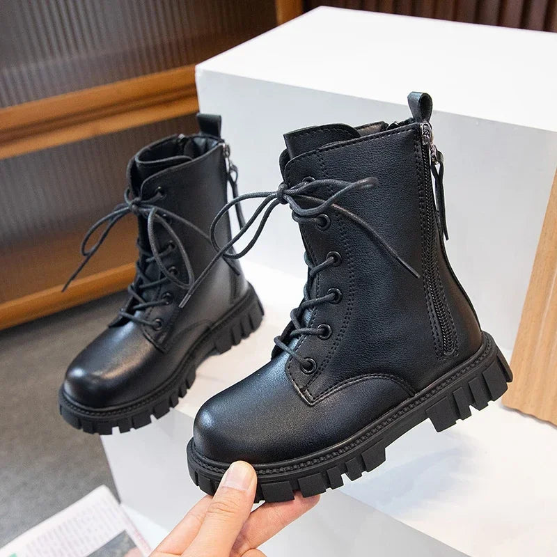 A pair of black girls' ankle boots with laces and an anti-skid rubber sole displayed on a white surface.