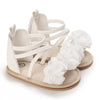 A pair of white breathable baby first walker sandals with soft anti-slip soles.