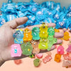 A hand holds a collection of glow-in-the-dark mini animal figures in various colors and shapes.