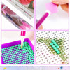 Diamond painting kit components including a purple tray, paint brush, canvas, and various beads for cross stitch art