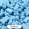 A pile of light blue bear-shaped acrylic craft beads with a shimmer finish