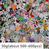 A close-up view of a large quantity of multicolor resin nail charms and embellishments.