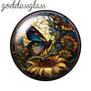 A round glass cabochon featuring a detailed floral design with yellow, orange, and blue hues.