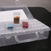 A clear storage box for diamond painting supplies featuring multiple organizer trays holding colored beads and stones.