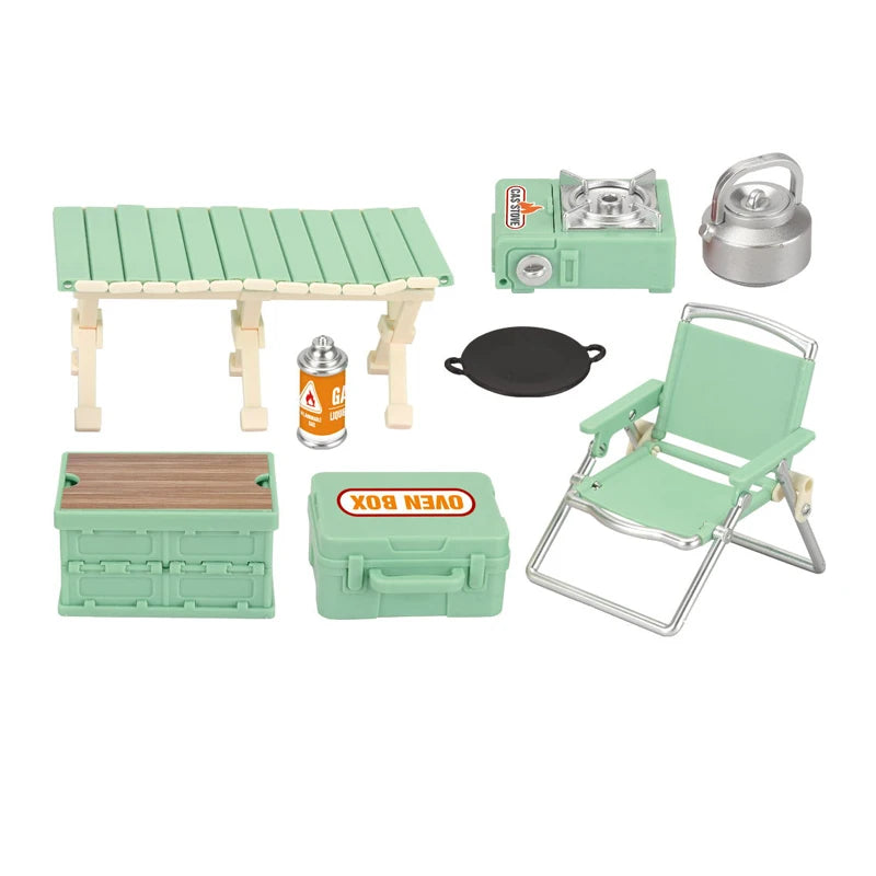 A miniature camping picnic set featuring a wooden table, cooking accessories, and a folding chair in light green.