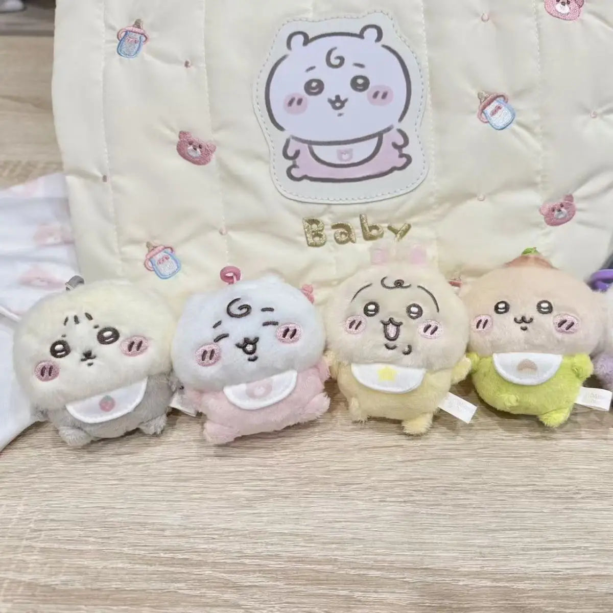 A set of four kawaii plush keychains featuring characters like Usagi, Hachiware, and JiYi against a light quilted fabric back
