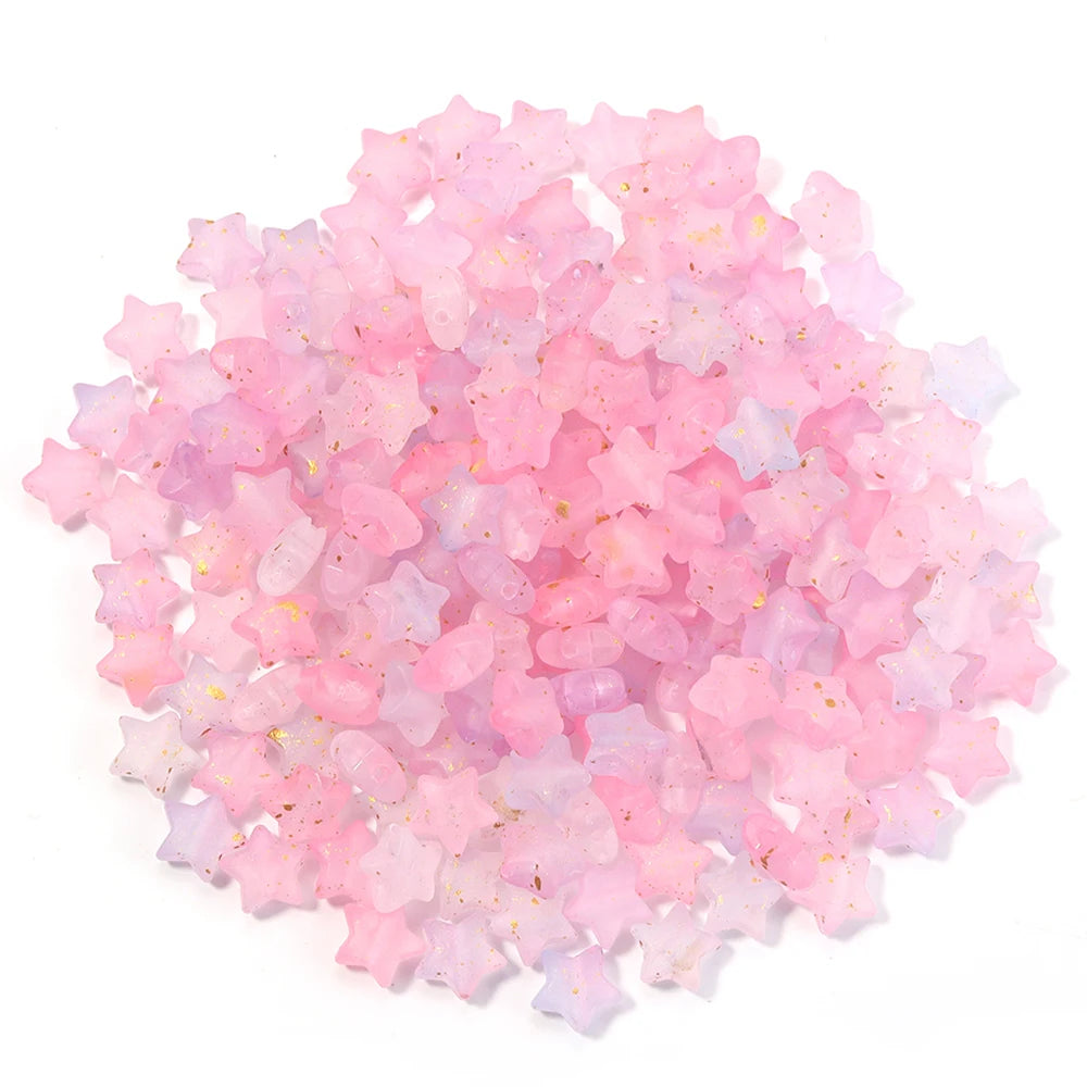 A pile of pink and purple transparent star acrylic beads for jewelry making