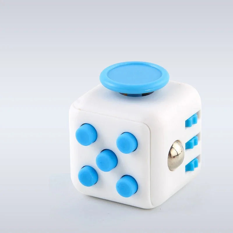 A white fidget cube with a blue rotating joystick and magnetic buttons.