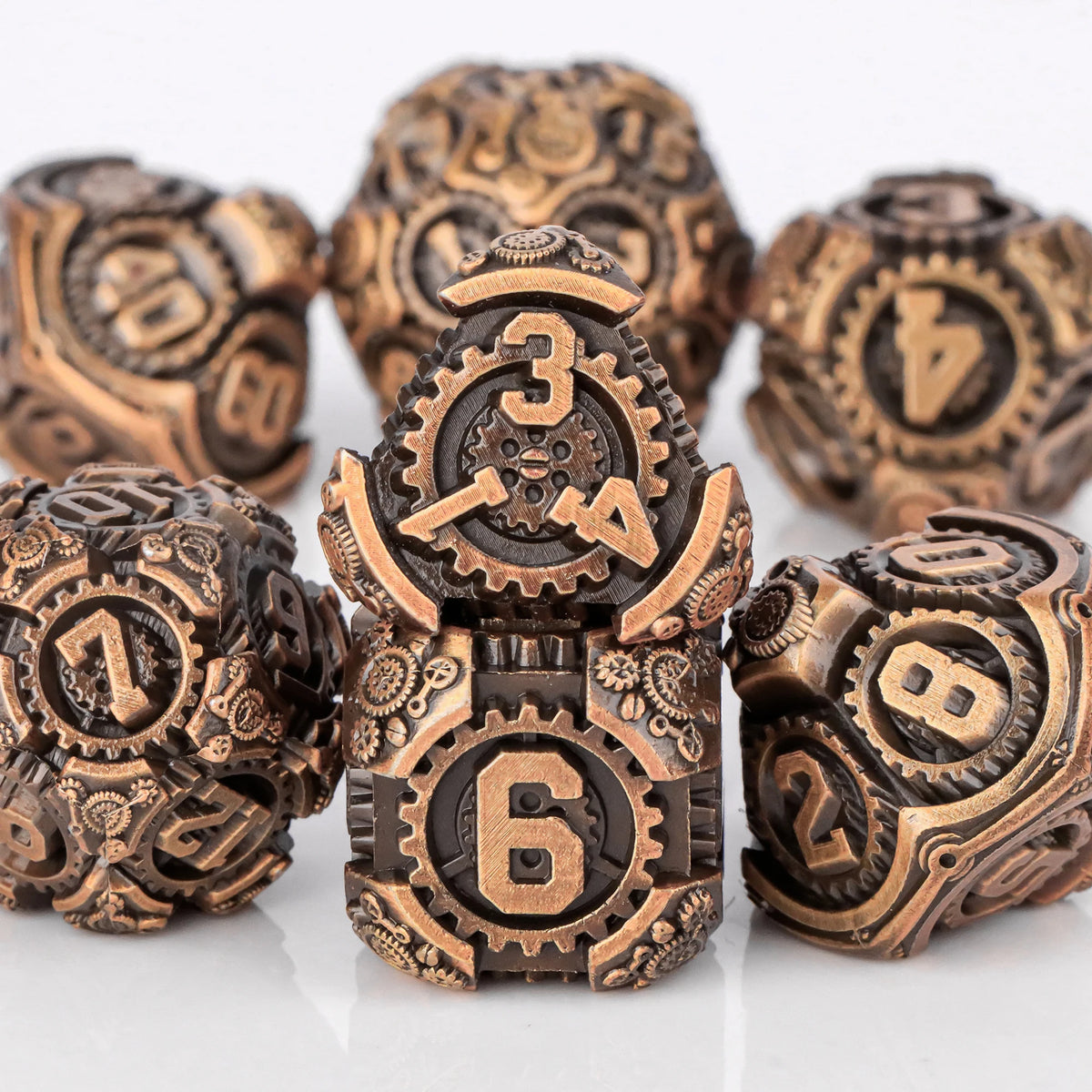 A set of seven metal dice featuring skulls and dragons in various numbers and shapes.