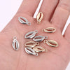 A collection of 50 plastic seashell charms in silver and gold tones for jewelry making.