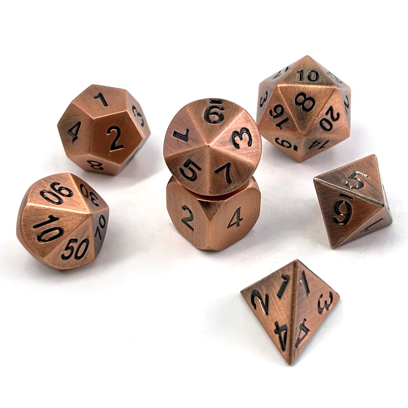 A set of premium metal polyhedral dice with a multicolor gold finish scattered on a white surface.