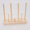 A wooden ribbon bow maker with several wooden dowels and a base for crafting.