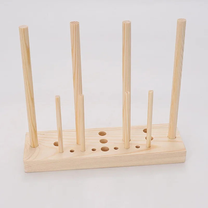A wooden ribbon bow maker with several wooden dowels and a base for crafting.