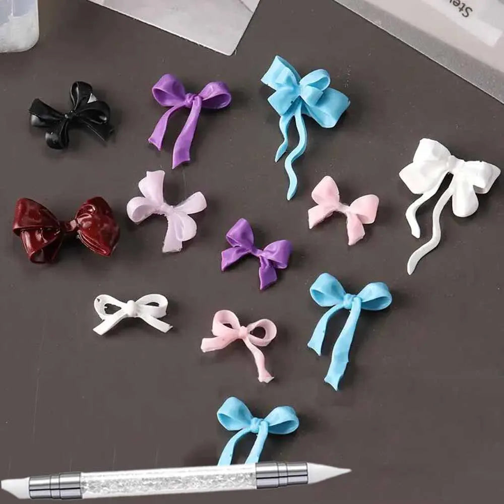 A collection of silicone bowknot nail molds in various colors including purple, blue, pink, and white, displayed on a dark su