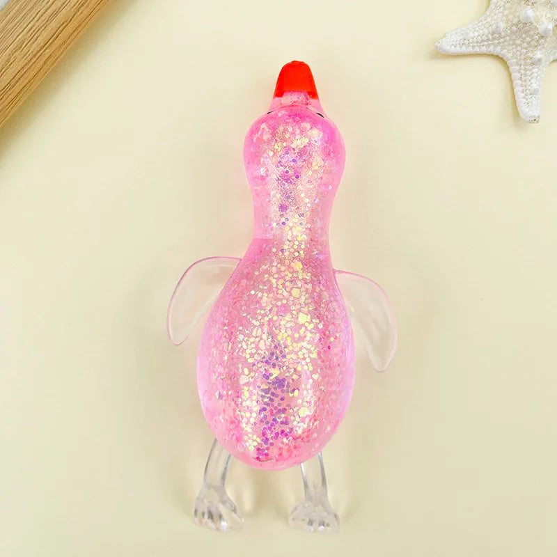 A pink, glittery stretchy duck squeeze toy with a red beak and translucent wings.