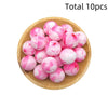 A wooden bowl filled with ten pink and white marbled silicone beads for DIY jewelry making