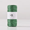 A spool of metallic green yarn for knitting and crochet with a white label.