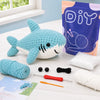 Kit de crochet débutant pour animaux amigurumi, montrant le fil, les aiguilles et un poisson-requin bleu terminé.