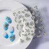 A sheet of 5D Bronzing Gothic nail art stickers featuring various floral and leaf designs on a white plate.