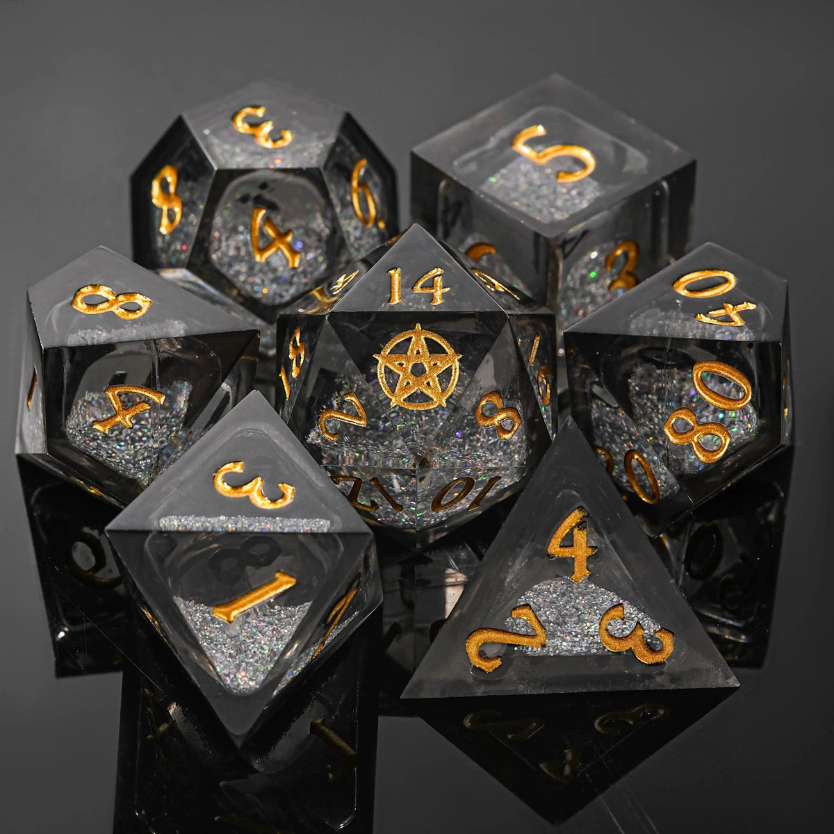 A set of seven polyhedral liquid core resin dice, including d4, d8, d10, d12, d20, and d100, displayed on a dark surface.