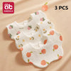 Three white cotton gauze baby bibs with strawberry and leaf patterns are displayed on a beige background.