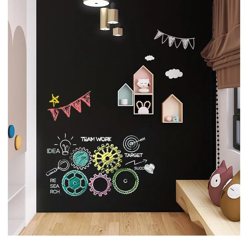 A dark wall decorated with various chalk drawings and decorative elements like clouds and garlands for a kids' chalkboard pan