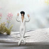 A white plush doll resembling Elvis Presley with black hair and sunglasses standing on a snowy surface.